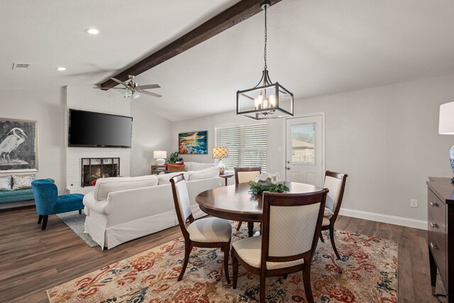 dining space with visible vents, dark wood-style floors, a fireplace, baseboards, and vaulted ceiling with beams