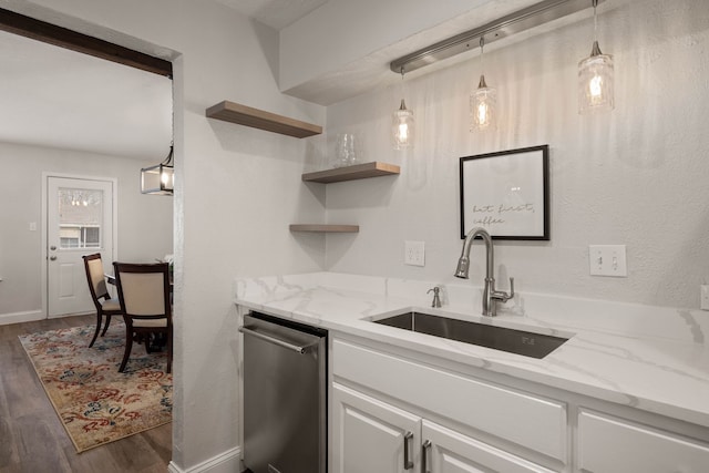 kitchen with a sink, stainless steel dishwasher, white cabinetry, light stone countertops, and dark wood-style flooring