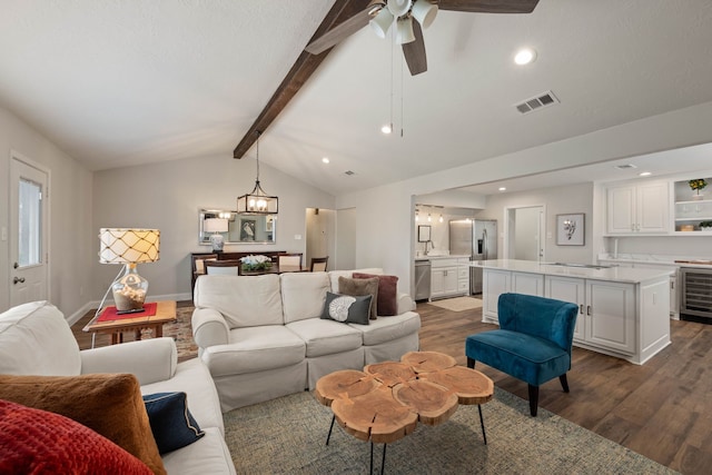 living area with visible vents, dark wood-type flooring, lofted ceiling with beams, wine cooler, and baseboards