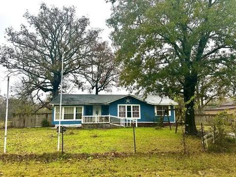 ranch-style home featuring a front lawn and fence