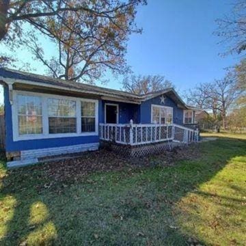 view of front facade featuring a deck and a front lawn