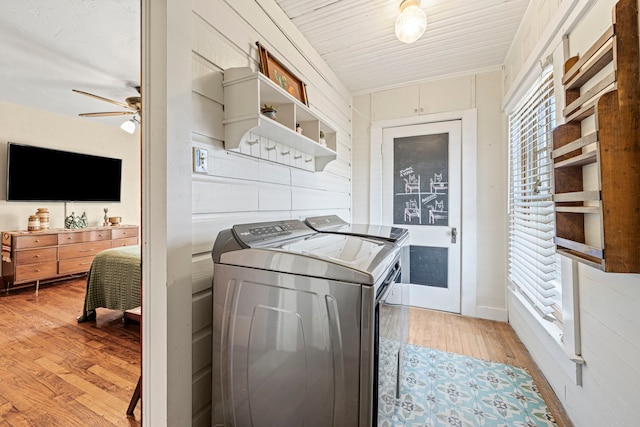 clothes washing area with washer and dryer, ceiling fan, laundry area, and light wood finished floors