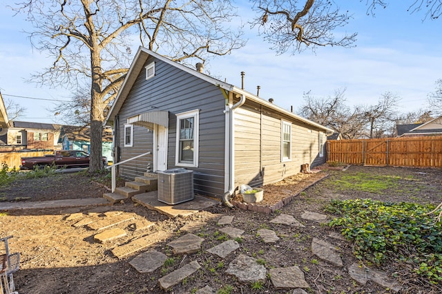 exterior space featuring central AC unit, entry steps, and fence