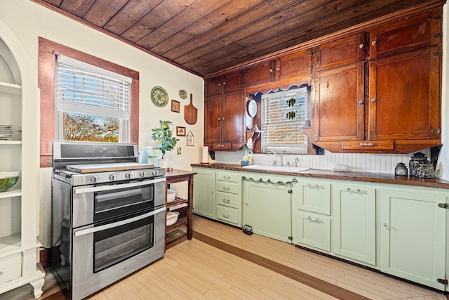 kitchen featuring a sink, double oven range, wooden ceiling, light wood finished floors, and green cabinetry