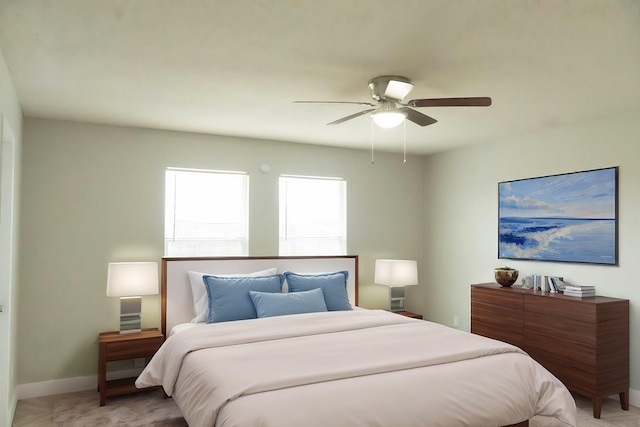 bedroom featuring light carpet, a ceiling fan, and baseboards