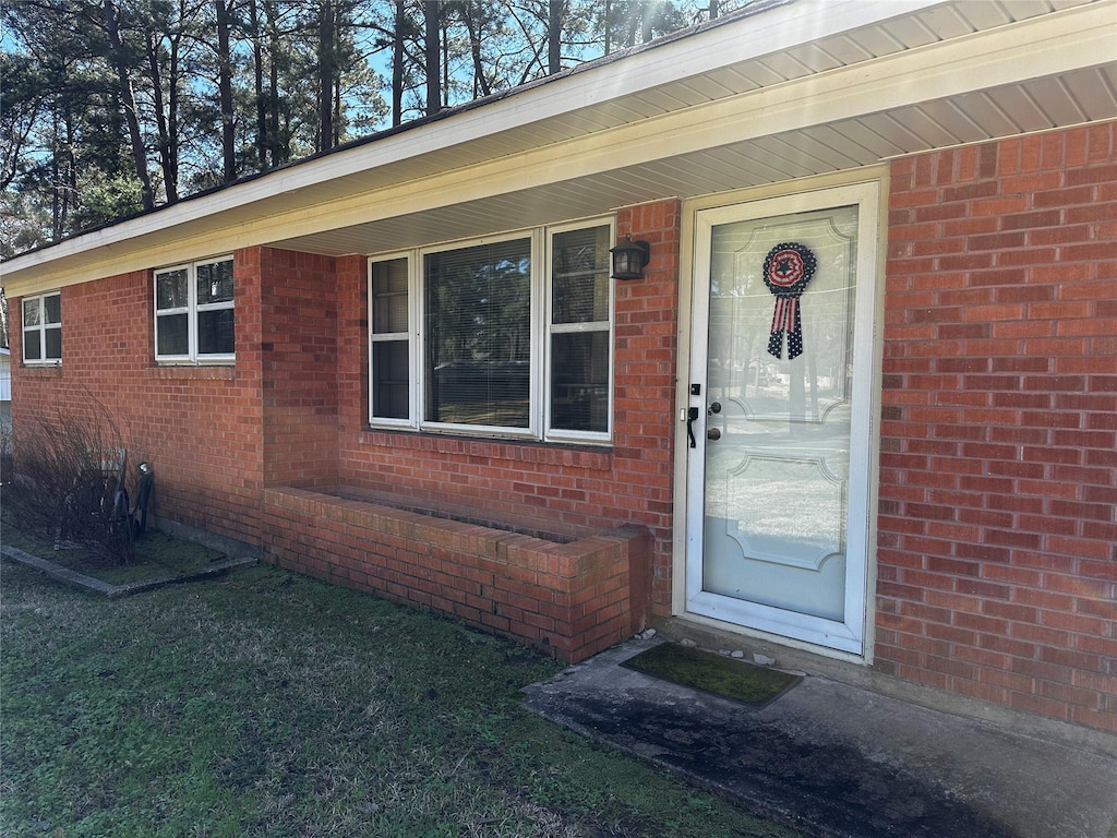 view of exterior entry featuring brick siding