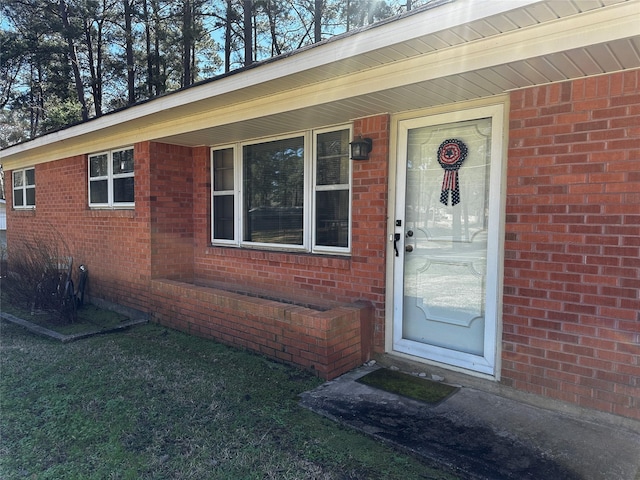 view of exterior entry featuring brick siding