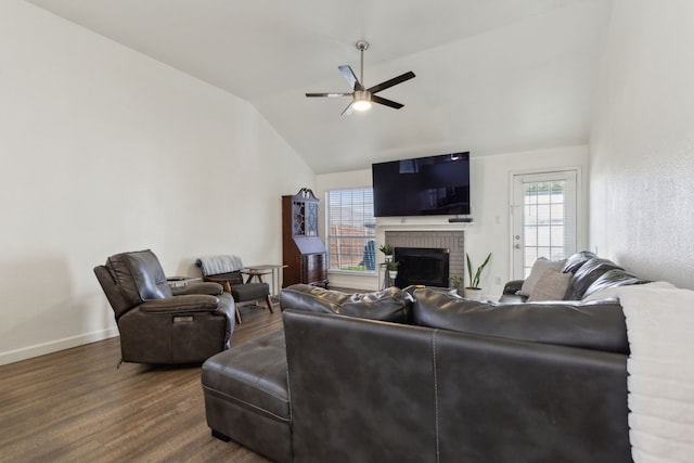 living room featuring a brick fireplace, ceiling fan, baseboards, dark wood finished floors, and lofted ceiling