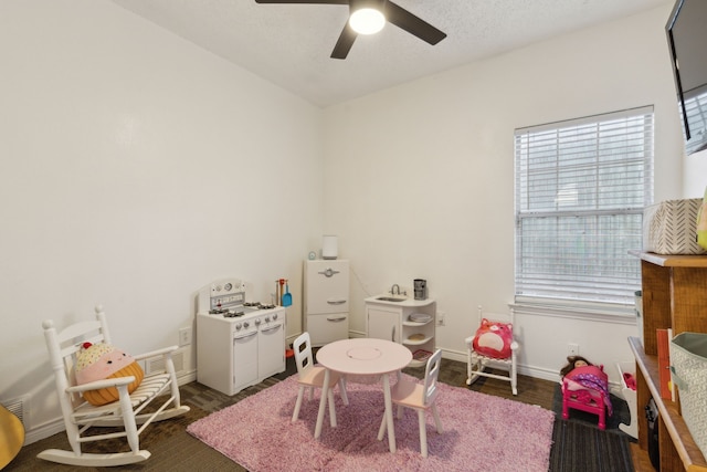 playroom with wood finished floors, baseboards, and ceiling fan