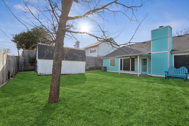 view of yard featuring an outbuilding, a storage shed, central AC, and a fenced backyard