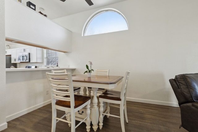 dining room with baseboards, plenty of natural light, dark wood-type flooring, and a ceiling fan