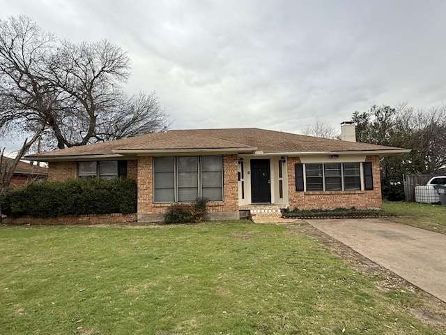 ranch-style home with a front lawn, brick siding, and a chimney