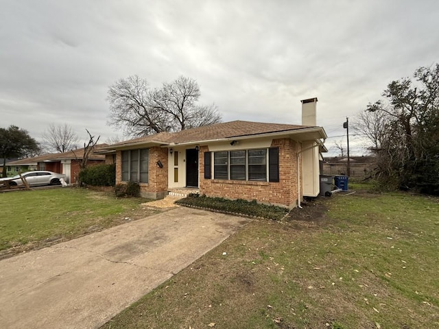 view of front of house with a front yard, brick siding, and a chimney