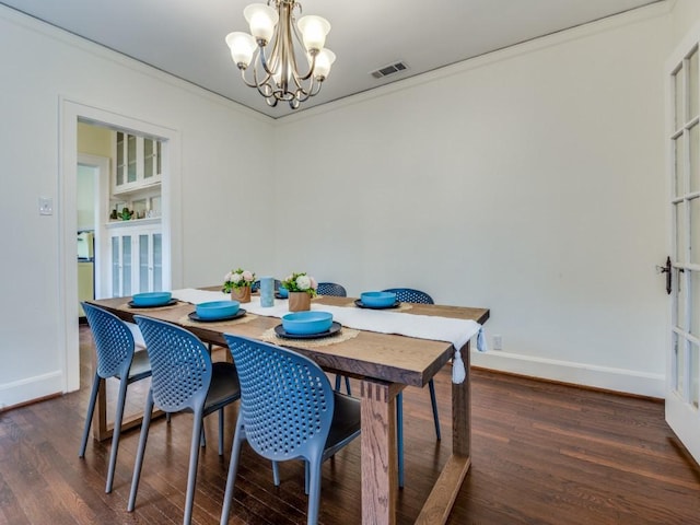 dining room featuring baseboards, dark wood-type flooring, an inviting chandelier, and ornamental molding