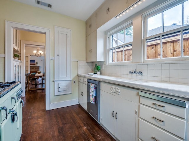 kitchen featuring visible vents, tile countertops, an inviting chandelier, decorative backsplash, and dishwasher