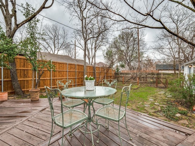 wooden deck with outdoor dining area and a fenced backyard