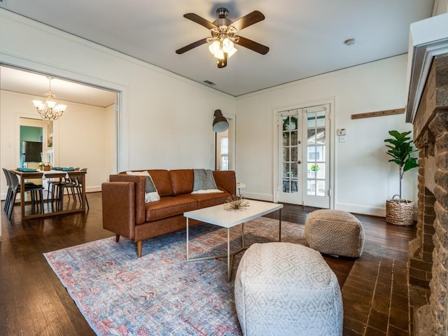 living room featuring visible vents, baseboards, ornamental molding, ceiling fan with notable chandelier, and hardwood / wood-style flooring