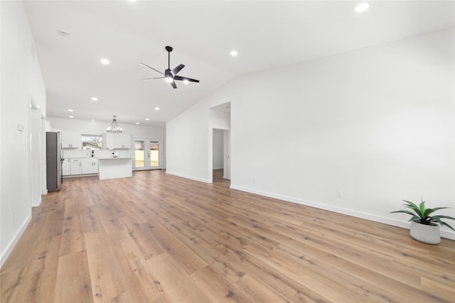 unfurnished living room with lofted ceiling, light wood-style flooring, recessed lighting, and baseboards