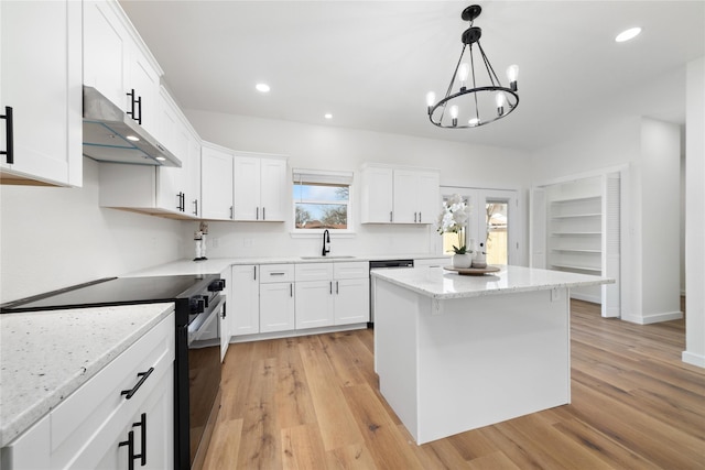 kitchen featuring a sink, under cabinet range hood, range with electric stovetop, white cabinetry, and a center island