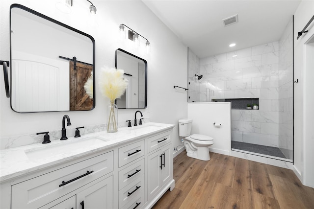 full bathroom featuring wood finished floors, visible vents, a sink, a walk in shower, and toilet