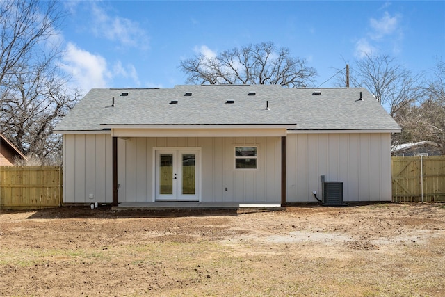 rear view of house with central AC, fence, french doors, board and batten siding, and a shingled roof