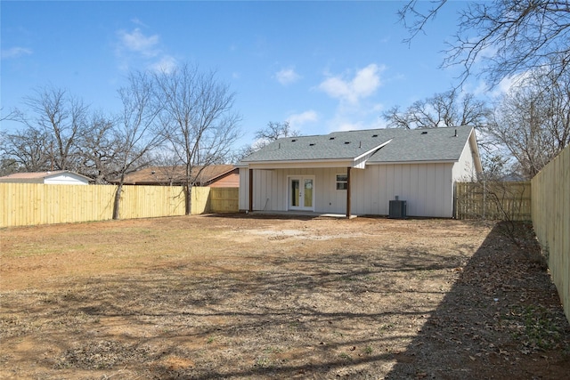 back of property with central air condition unit, french doors, and a fenced backyard