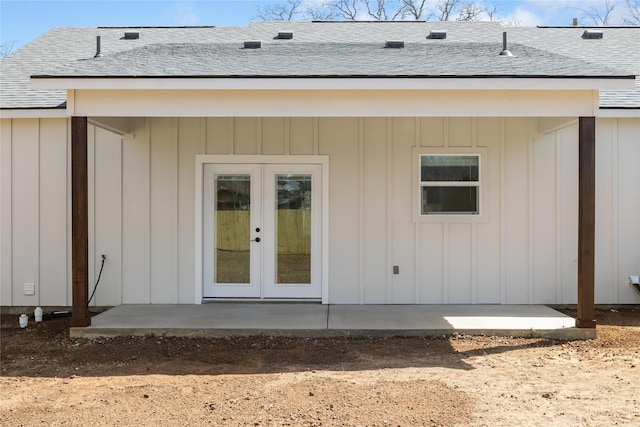 doorway to property featuring french doors, a patio area, board and batten siding, and a shingled roof