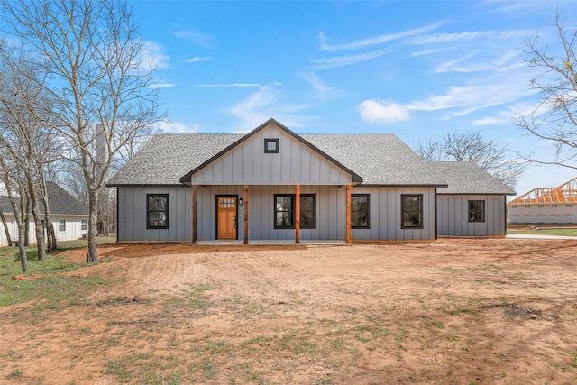 view of front of house with board and batten siding, roof with shingles, and covered porch