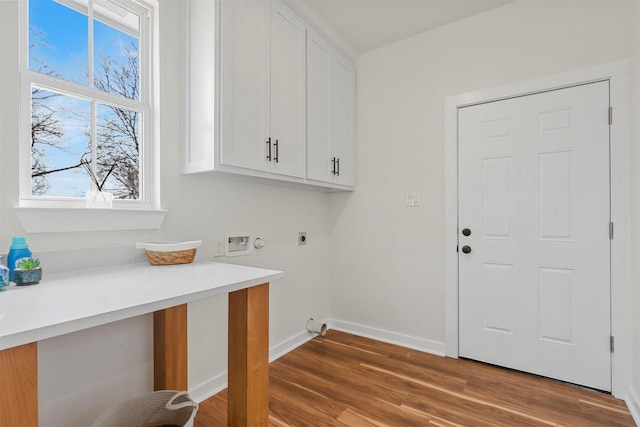 clothes washing area with baseboards, washer hookup, wood finished floors, cabinet space, and electric dryer hookup