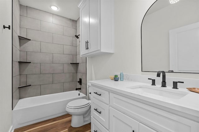 bathroom with shower / bathing tub combination, toilet, wood finished floors, and vanity