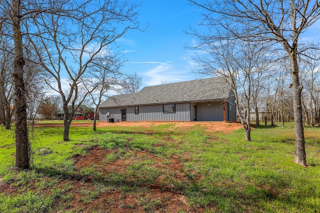 exterior space with an outbuilding, a lawn, and a shingled roof