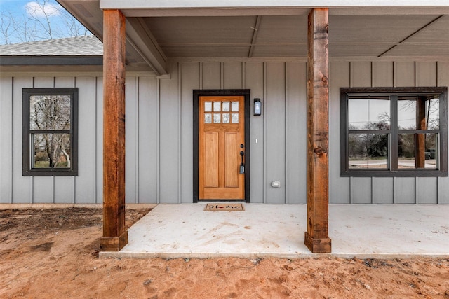 property entrance featuring board and batten siding and roof with shingles