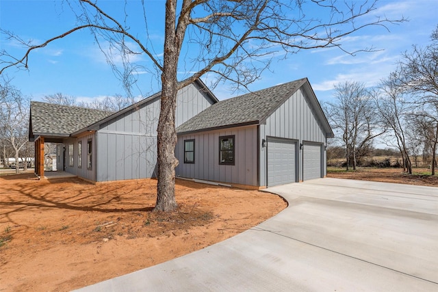 view of side of property with board and batten siding, driveway, and a shingled roof