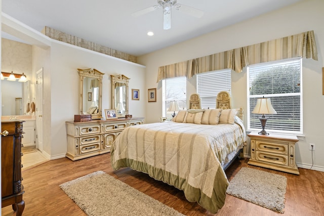 bedroom with wood finished floors, baseboards, ensuite bathroom, and ceiling fan