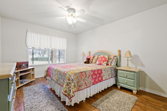 bedroom featuring dark wood finished floors, a ceiling fan, and baseboards