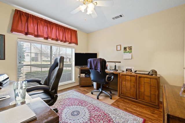 home office featuring wood finished floors, visible vents, and ceiling fan