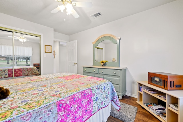 bedroom with visible vents, wood finished floors, a closet, baseboards, and ceiling fan