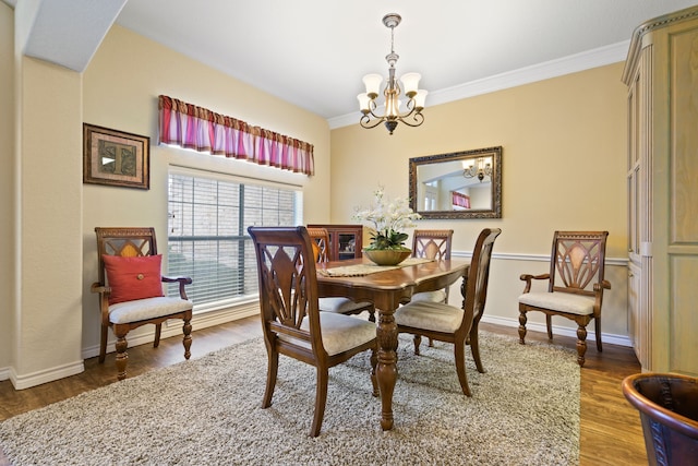 dining room featuring crown molding, wood finished floors, baseboards, and a chandelier