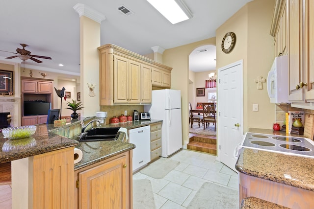 kitchen with visible vents, a sink, white appliances, arched walkways, and decorative backsplash