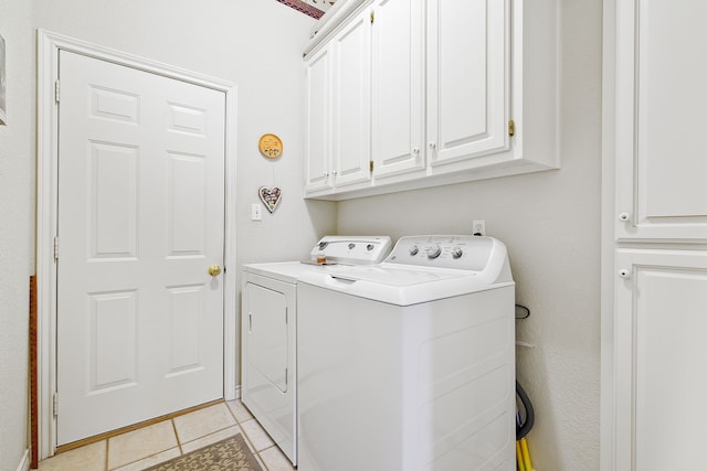 washroom featuring light tile patterned floors, cabinet space, and washing machine and dryer