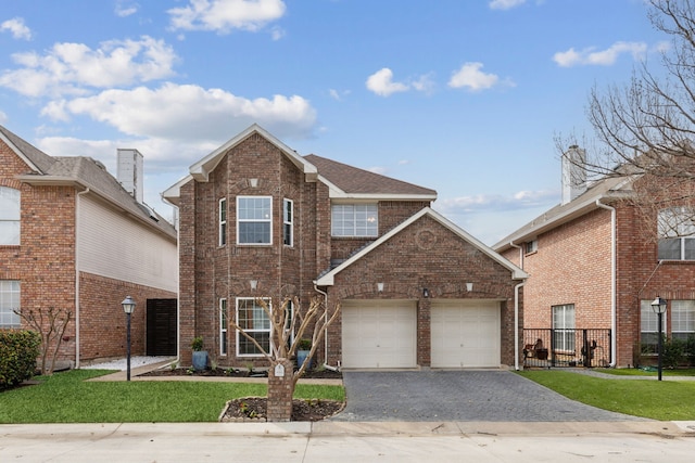 traditional-style home with a garage, a front yard, decorative driveway, and brick siding