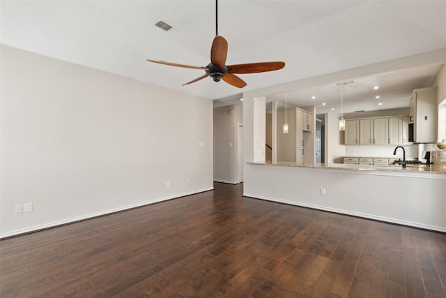 unfurnished living room with visible vents, baseboards, dark wood-type flooring, and ceiling fan