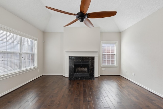 unfurnished living room with a premium fireplace, a textured ceiling, hardwood / wood-style floors, and vaulted ceiling