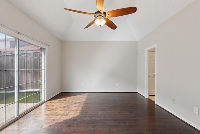 empty room featuring a wealth of natural light, wood finished floors, and vaulted ceiling