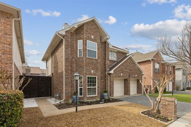 view of front of home with a gate, a chimney, a garage, aphalt driveway, and brick siding