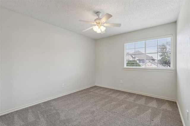 carpeted spare room featuring a textured ceiling, baseboards, and ceiling fan