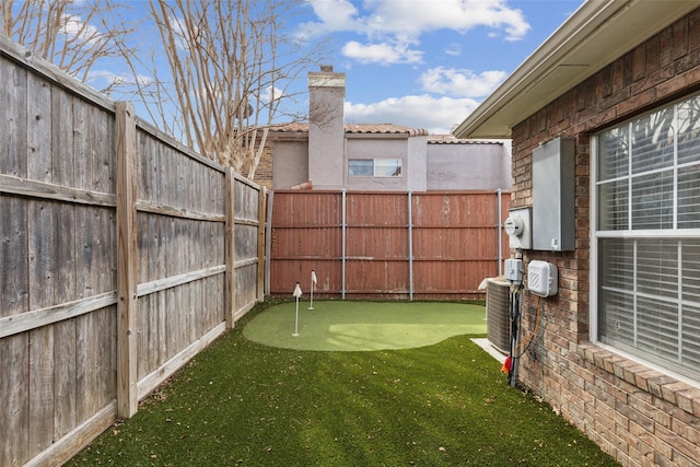 view of yard with central air condition unit and fence