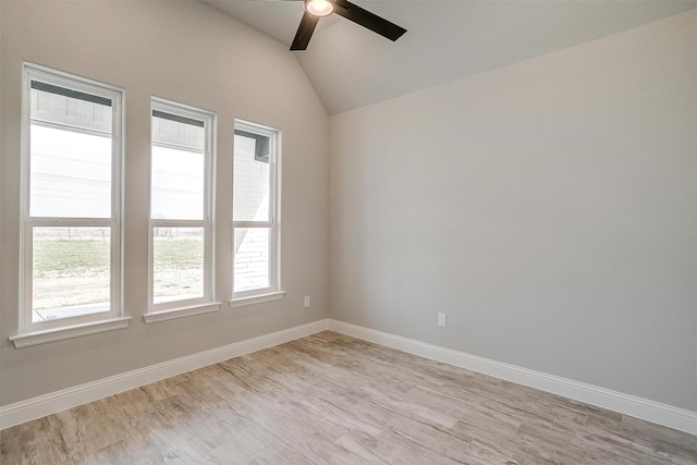 unfurnished room featuring light wood-style flooring, a ceiling fan, baseboards, and vaulted ceiling