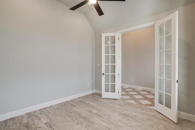 unfurnished room featuring baseboards, light wood-style flooring, ceiling fan, vaulted ceiling, and french doors