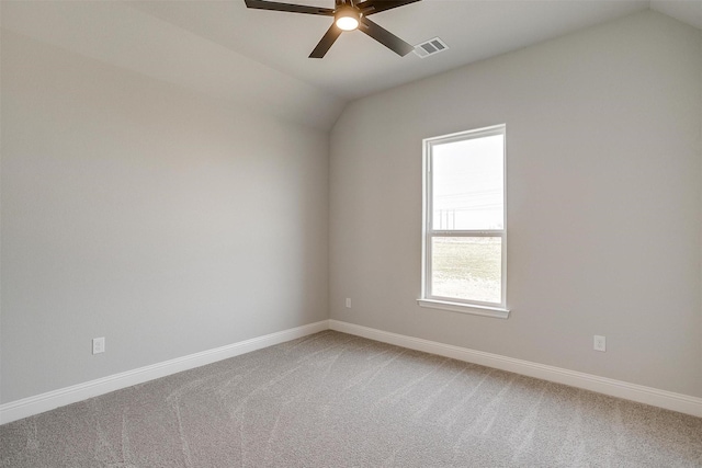 empty room featuring visible vents, light carpet, baseboards, ceiling fan, and vaulted ceiling